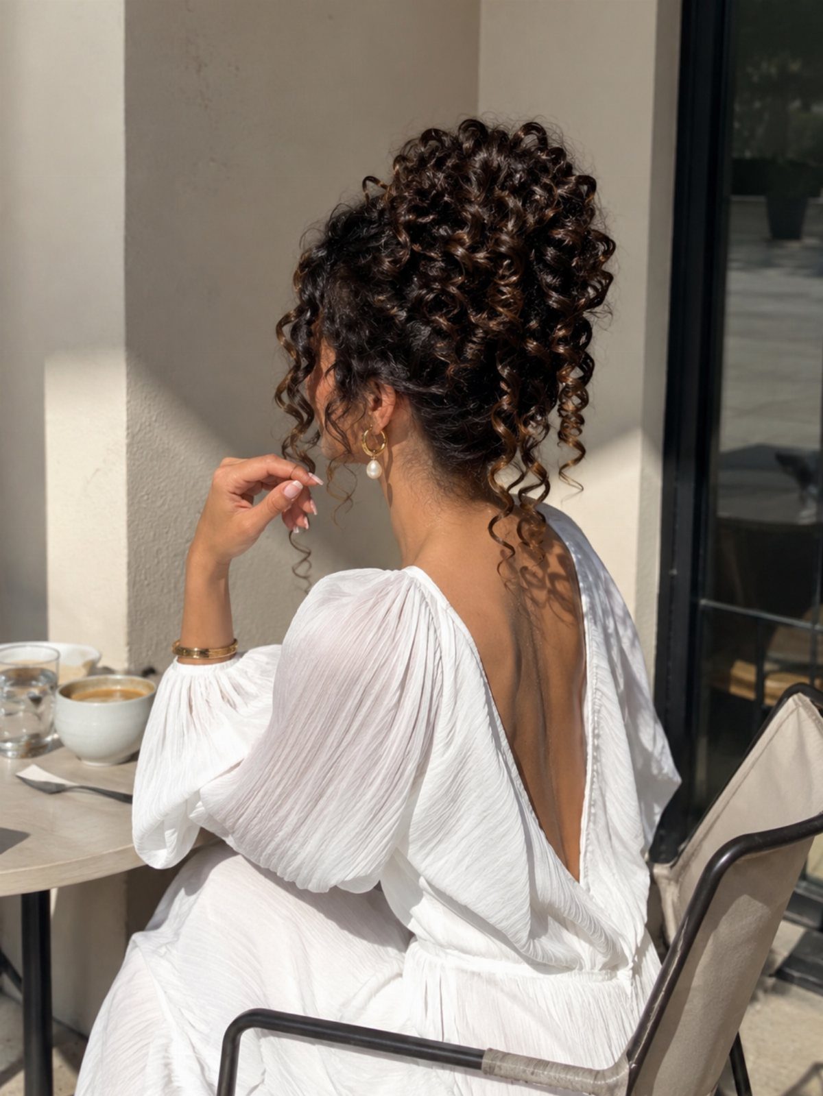Curly Hair Beauty Ideas: 11 Styles, Colors and Care 3 Woman with dark curly hair in a high ponytail wearing a white dress