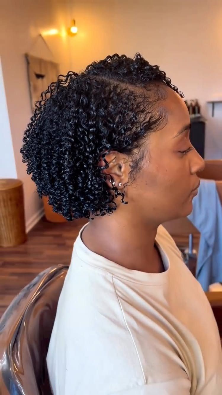 Curly Hair Beauty Ideas: 11 Styles, Colors and Care 5 Woman with short, glossy, defined black curls in a salon setting.