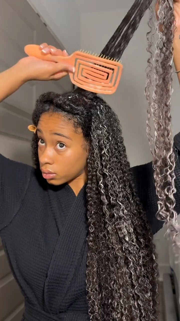 Curly Hair Beauty Ideas: 11 Styles, Colors and Care 1 Woman with long curly hair using an orange wide-toothed comb to detangle hair.
