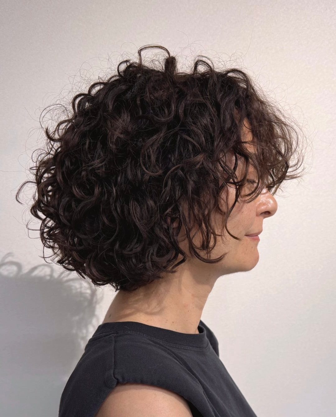 Curly Hair Design: 10 Ideas for Every Length and Texture 1 Person with a short, voluminous dark brown layered curly bob hairstyle.