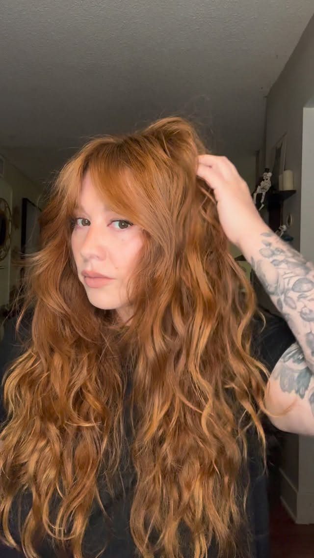 Curly Hair Design: 10 Ideas for Every Length and Texture 3 Woman with long reddish-brown curly hair and face-framing curtain bangs.