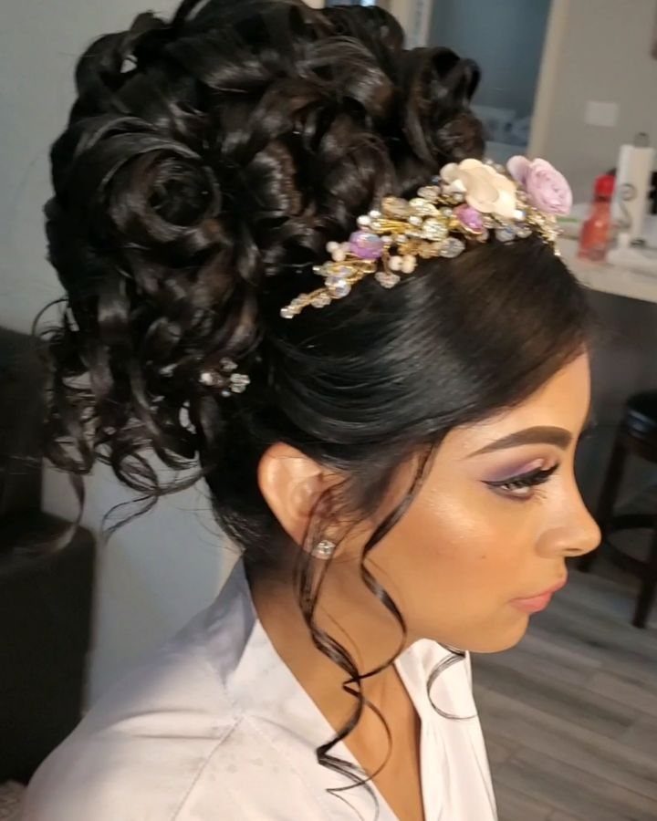 16 Cute Hairstyles for a Birthday Party, Waves to Braids 15 Woman with a high curly updo wearing a floral crown headband.