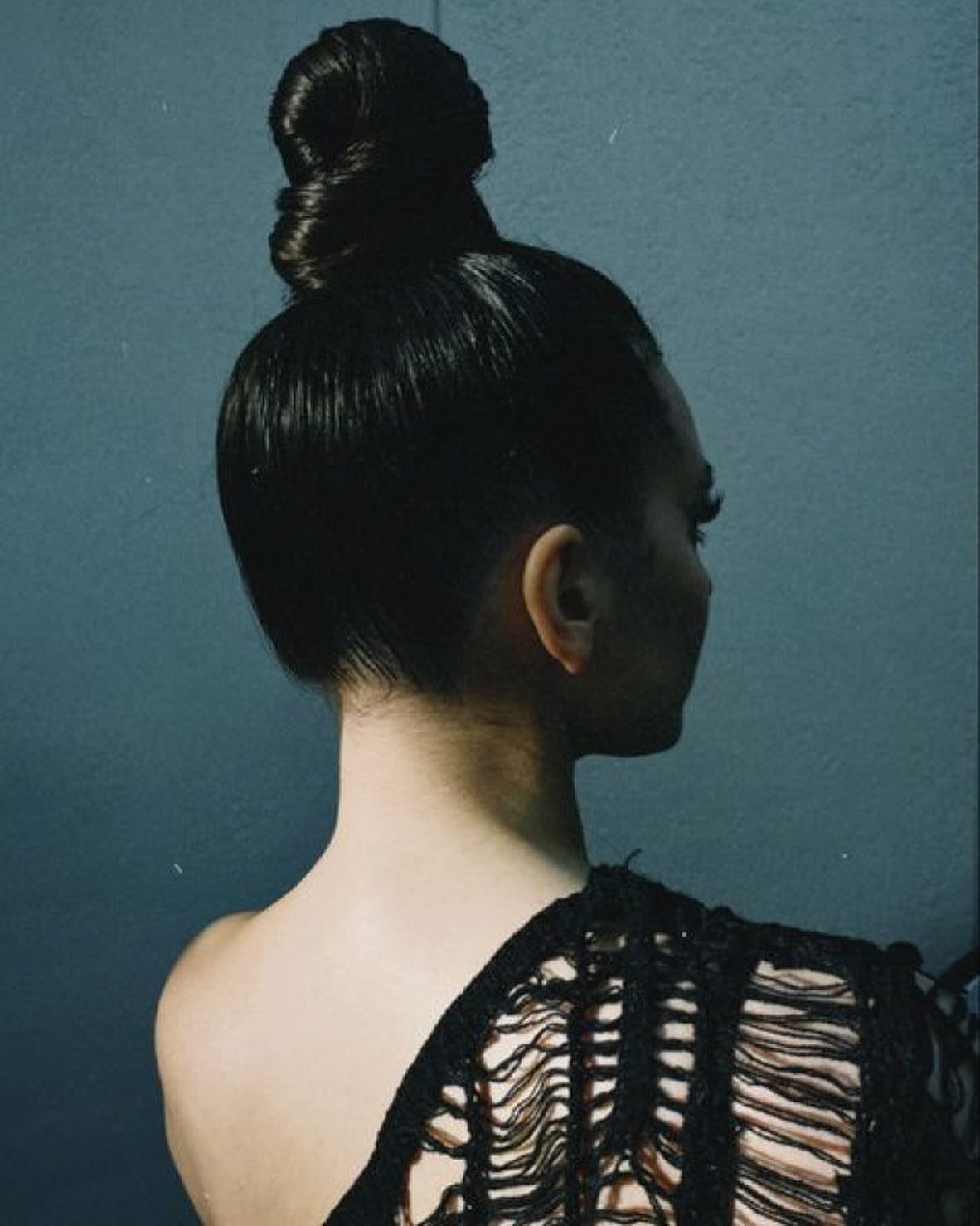 Cute Hairstyles for Hot Days: 11 Easy Ideas to Try 4 Woman with dark hair styled in a sleek, high top knot bun.