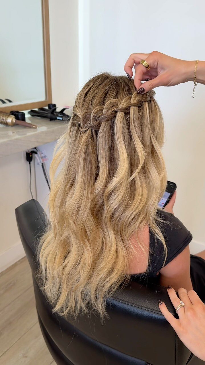 Cute Hairstyles for Hot Days: 11 Easy Ideas to Try 7 Blonde wavy hair styled into a waterfall braid by a professional hair stylist.
