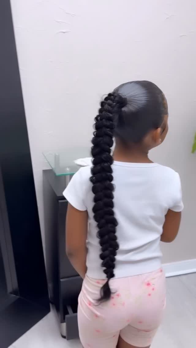 17 Cute Hairstyles for Picture Day, From Braids to Buns 5 Young girl with a long, dark bubble ponytail wearing a white t-shirt.