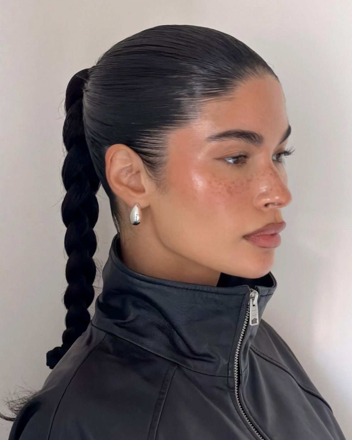 11 Cute Slick Backs: Braids, Buns, Ponytails and a Fade 1 Woman with slicked-back hair styled into a long, dark braided ponytail.