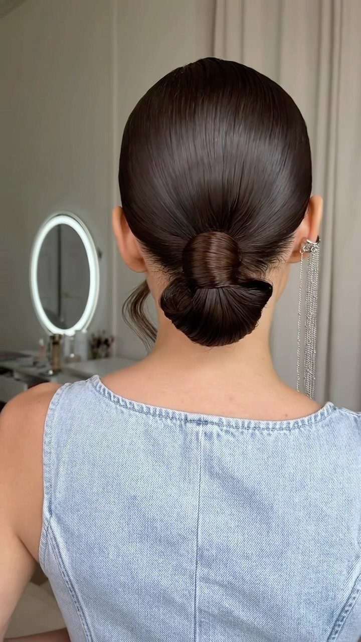 11 Cute Slick Backs: Braids, Buns, Ponytails and a Fade 2 Dark brown hair styled in a tight, slicked-back low bun from behind.