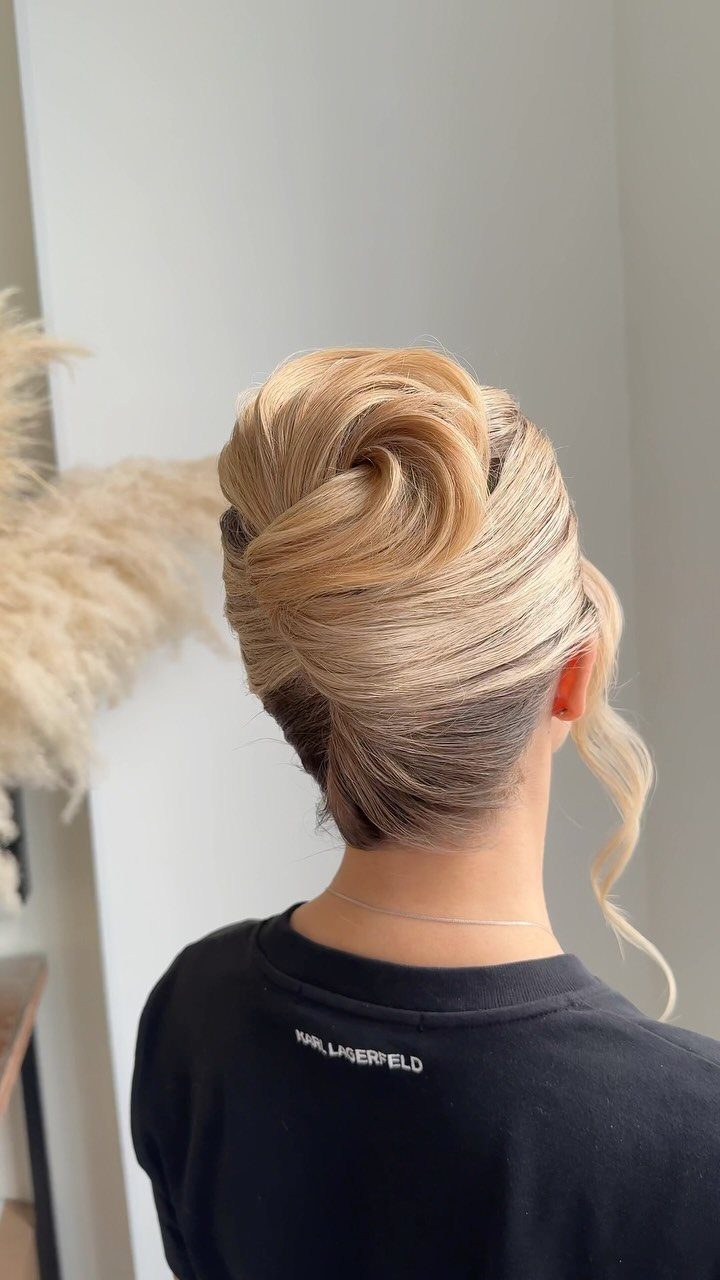 Blonde hair styled in a high sculpted twisted updo from the back