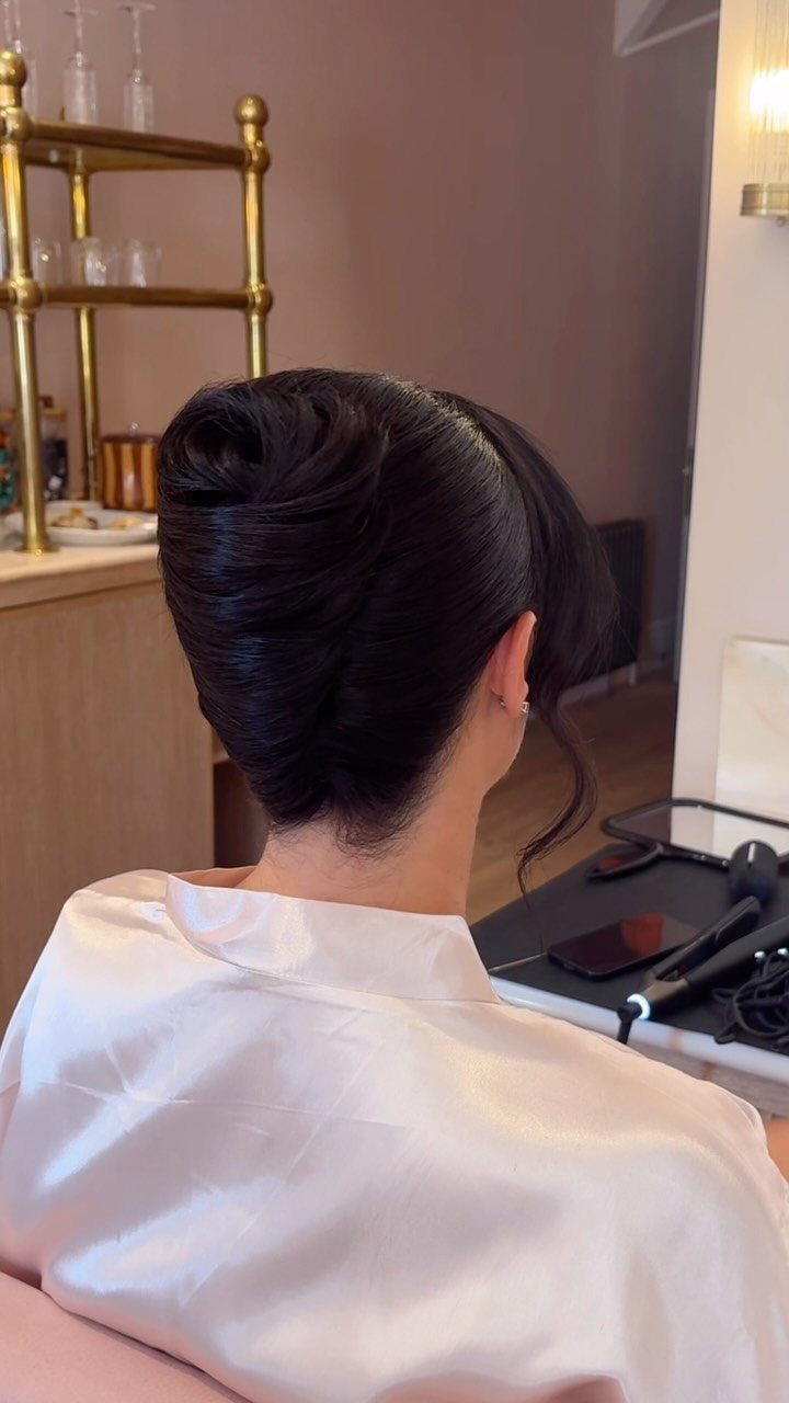 12 Cute Updo Hairstyles for Easy Everyday Styling 1 Dark hair styled in a polished French twist updo on a person.