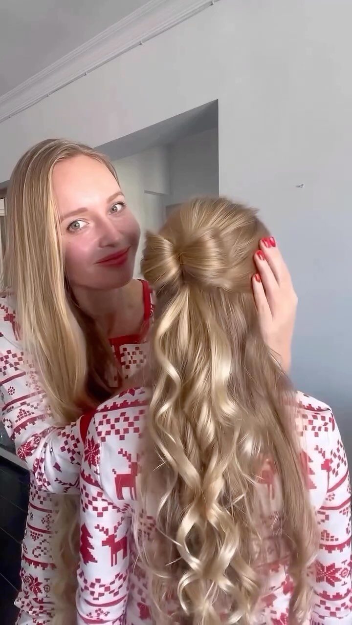 12 Cute Updo Hairstyles for Easy Everyday Styling 11 Blonde woman with a half-updo bow hairstyle and curls wearing festive pajamas.