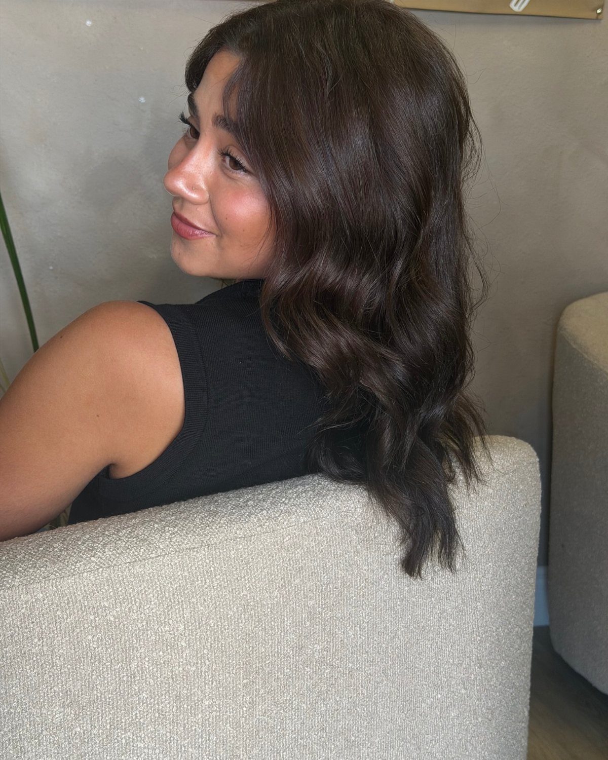 16 Dark Brunette Hair Color Ideas for Every Skin Tone 5 Woman with long wavy dark brown hair posing in a black top