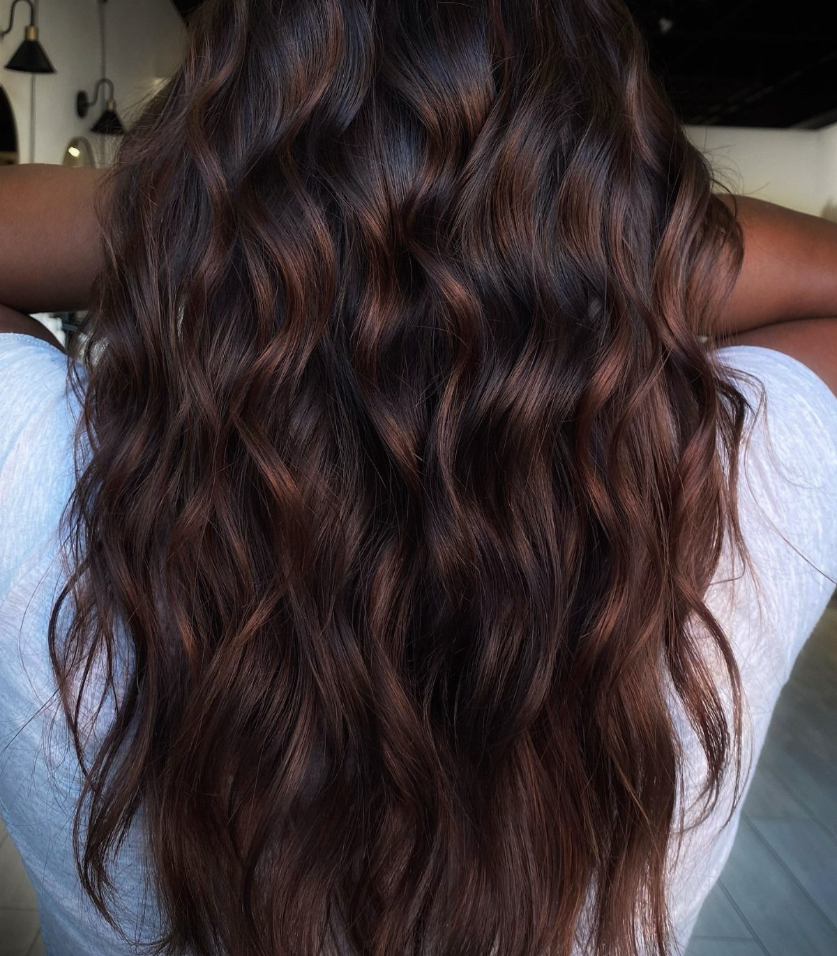 16 Dark Brunette Hair Color Ideas for Every Skin Tone 10 Long wavy deep brown hair with warm cinnamon and chestnut highlights from behind.