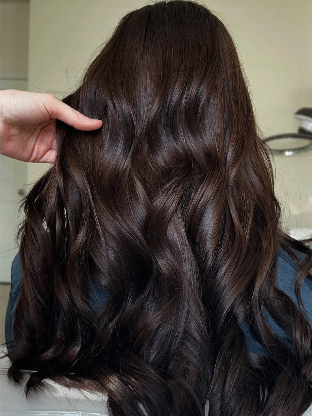 16 Dark Brunette Hair Color Ideas for Every Skin Tone 15 Long wavy dark brown hair with neutral undertones shown from the back.
