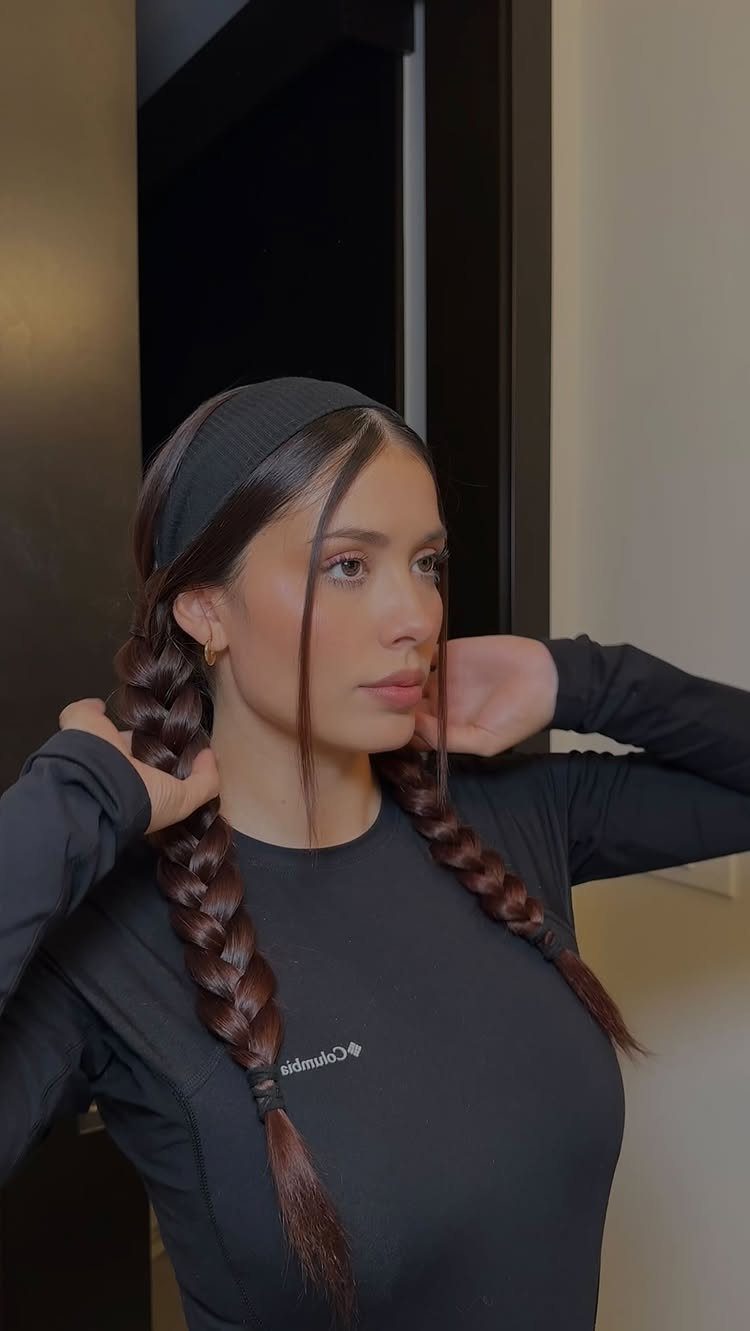 16 Easy Hair Styles for Beginners to Try at Home 8 Woman with brown hair wearing a black headband and two long braids.