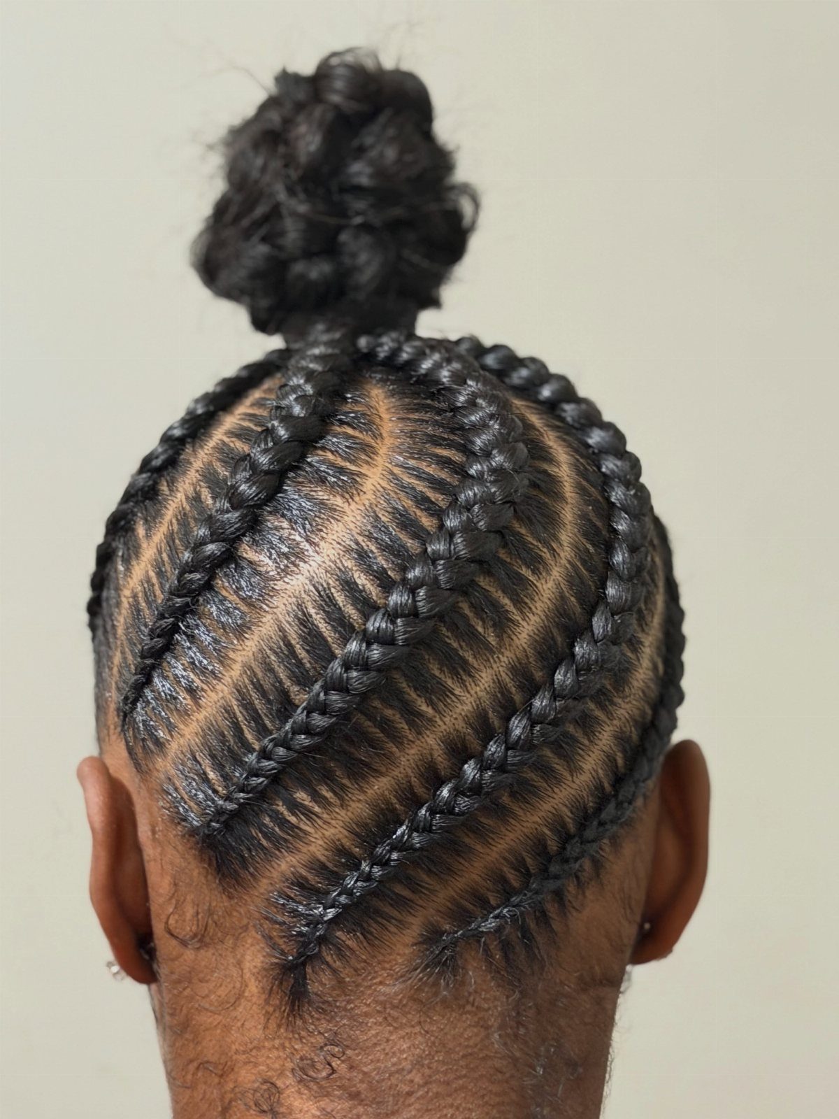 16 Easy Hair Styles for Beginners to Try at Home 14 Cornrow braids on a person's head leading into a small top bun.
