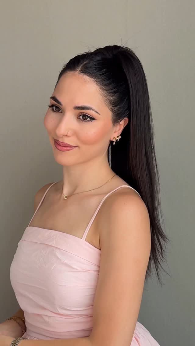 16 Easy Hair Styles for Beginners to Try at Home 13 Woman with long dark hair styled in a high sleek ponytail wearing pink dress