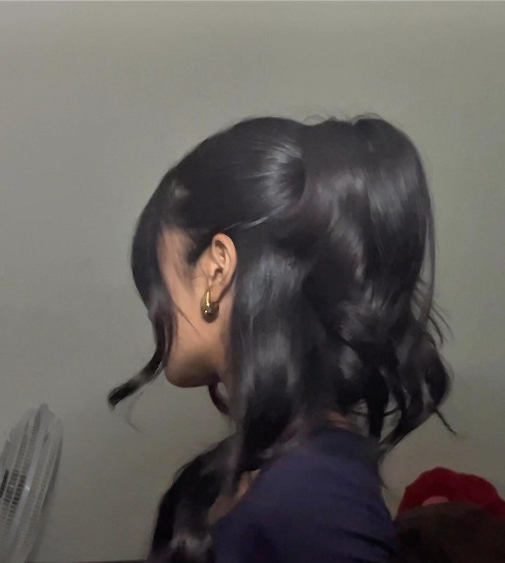18 Easy Hairstyles for Medium Hair You Can Do Fast 1 Person with dark wavy hair styled in a half-up bun and gold earrings.