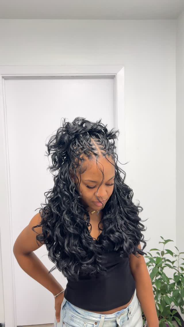 18 Easy Hairstyles for Medium Hair You Can Do Fast 12 Woman with curly black hair in a half-up braided hairstyle and black top.