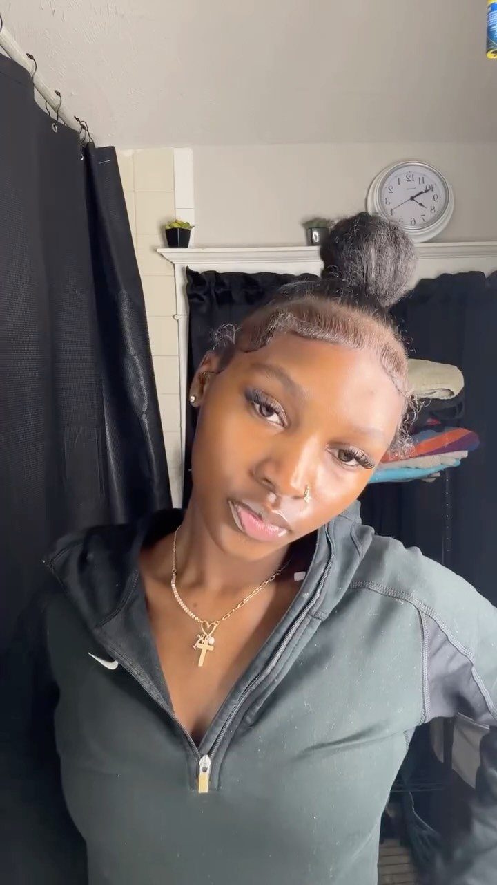 18 Easy Hairstyles for Medium Hair You Can Do Fast 10 Woman with dark natural hair styled in a high textured bun and laid edges.