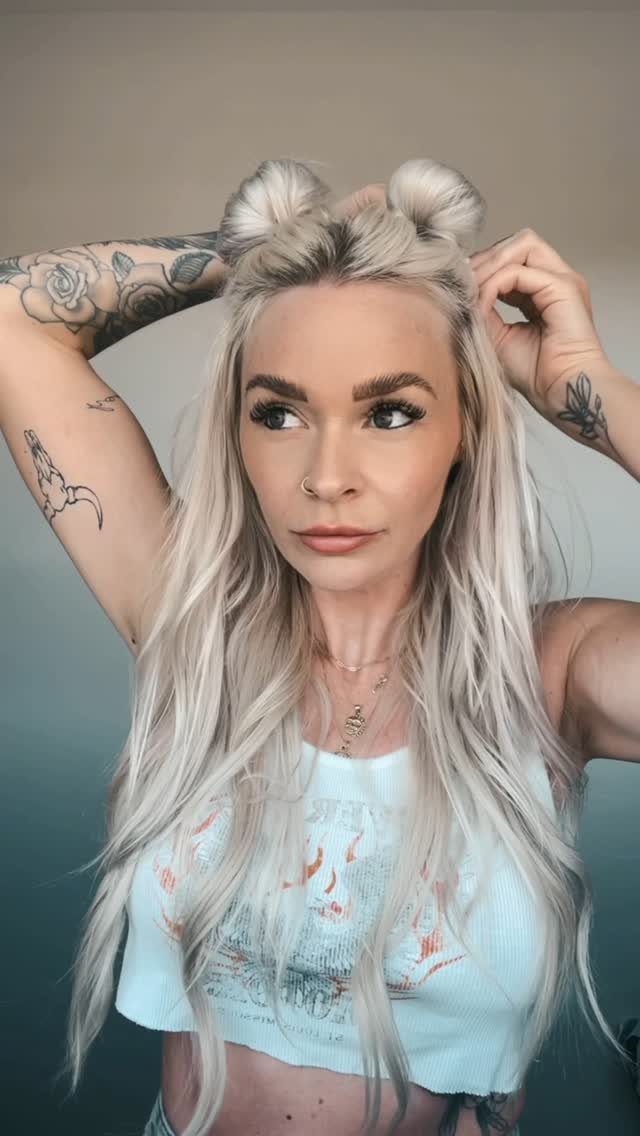 18 Easy Hairstyles for Medium Hair You Can Do Fast 9 Woman with blonde hair styled in space buns and loose flowing waves.