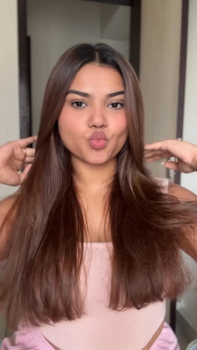 18 Easy Hairstyles for Medium Hair You Can Do Fast 2 Woman with straight brown medium-length hair parted in the middle wearing pink clothing.