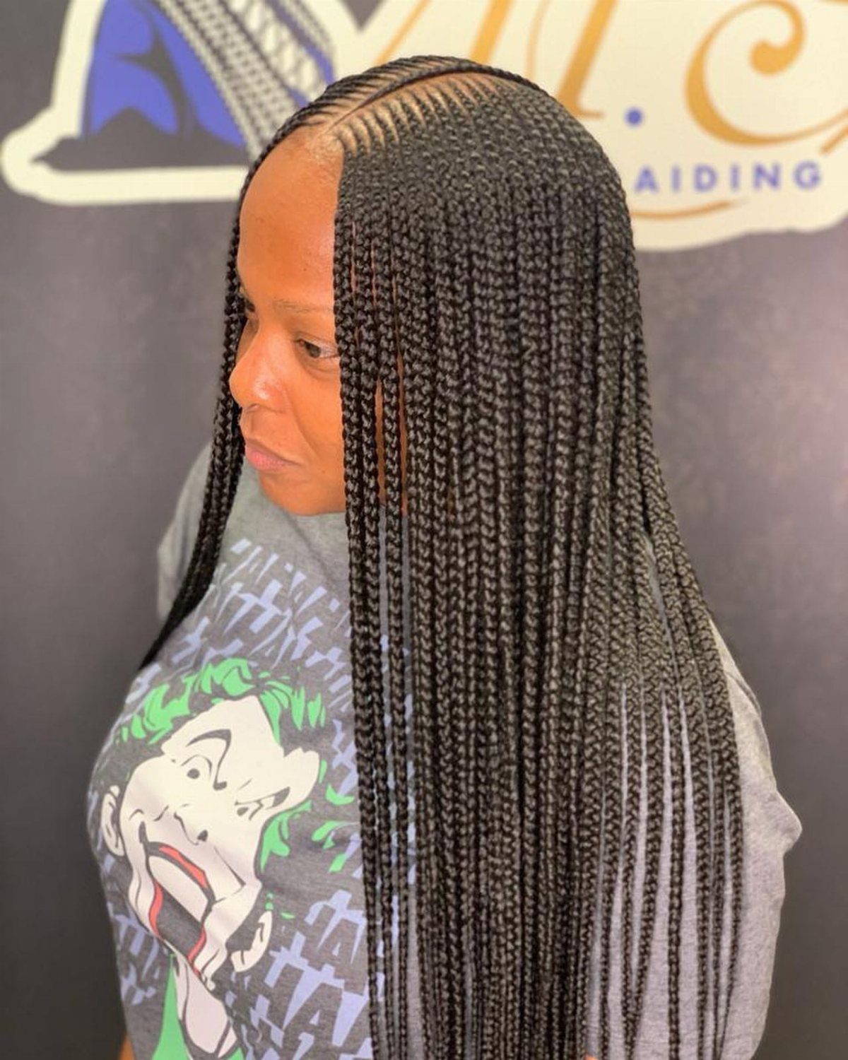 Woman with middle-part cornrows transitioning into long, black individual braids.
