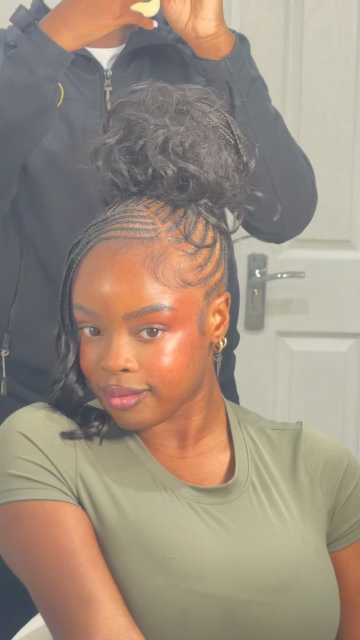 12 Good Hairstyles for Curly Hair, From Bangs to Braids 7 Woman with a braided updo and high curly bun wearing an olive green shirt