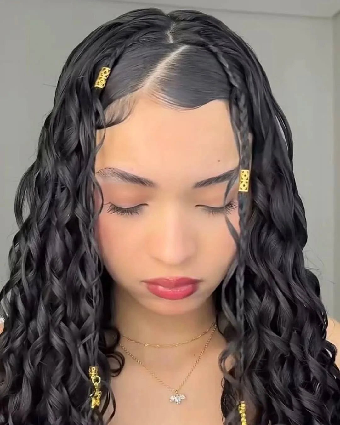 12 Good Hairstyles for Curly Hair, From Bangs to Braids 12 Woman with long curly black hair styled with braids and gold clips.