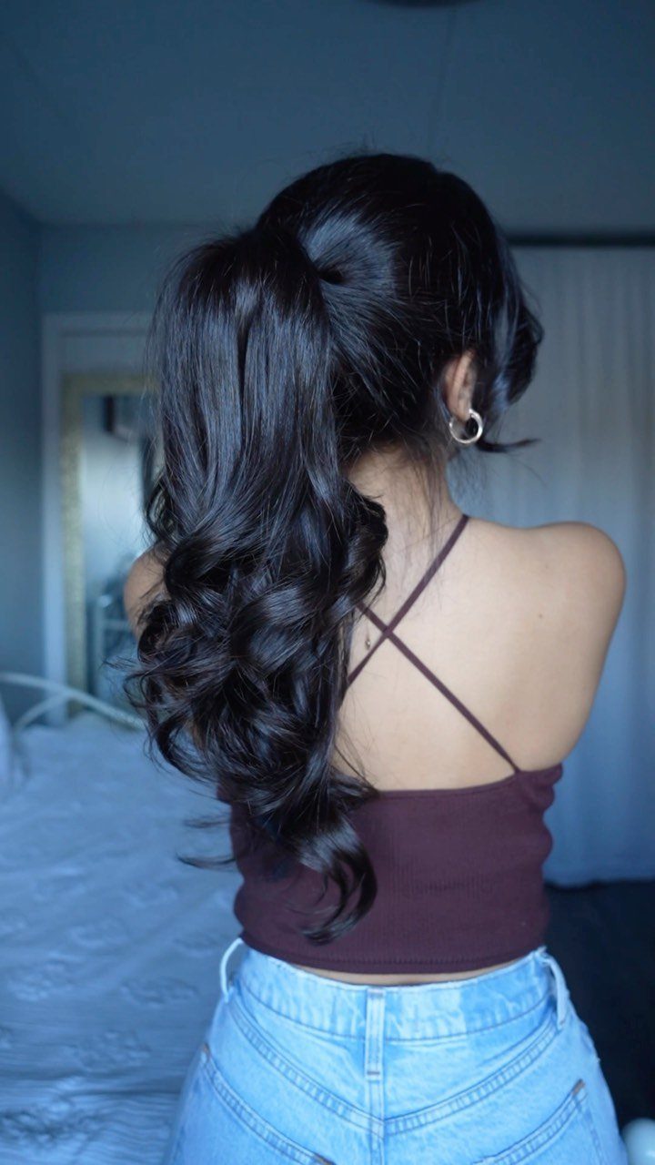 12 Good Hairstyles for Curly Hair, From Bangs to Braids 11 Woman with long dark curly hair styled in a high ponytail from behind.