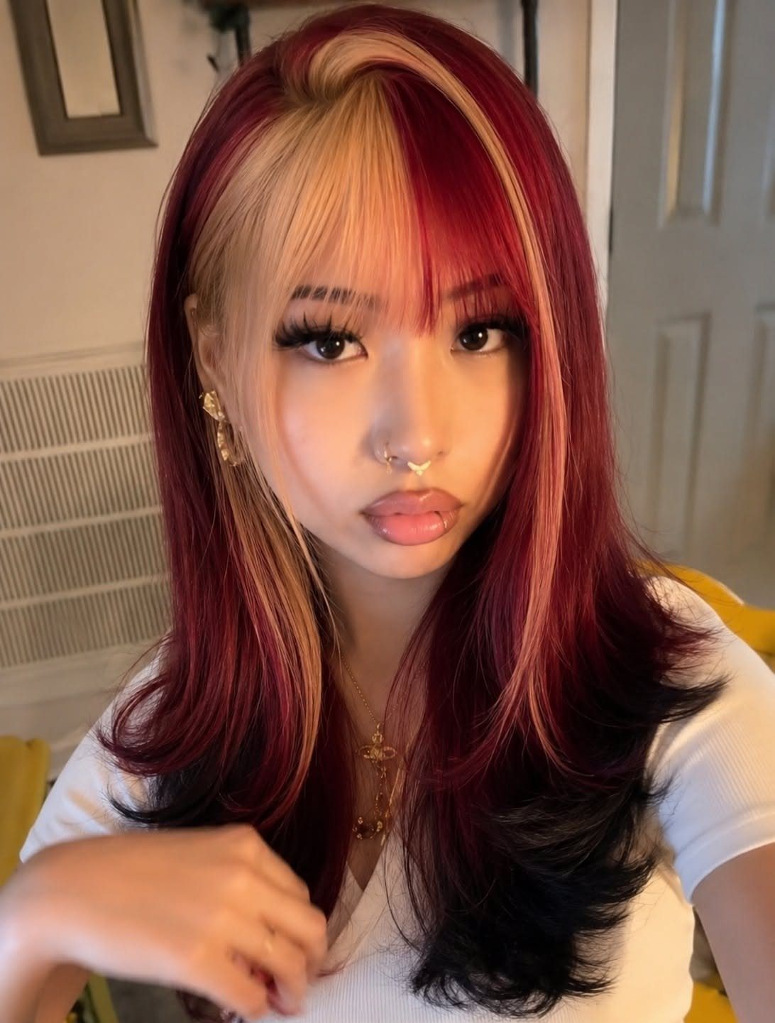 22 Hair Color Red and Blonde Ideas for Every Length 9 Woman with bright cherry red hair and blonde money piece face-framing highlights.