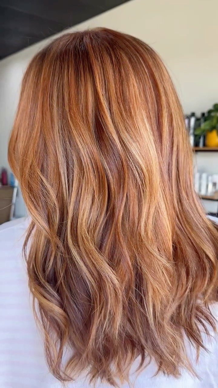 22 Hair Color Red and Blonde Ideas for Every Length 15 Long wavy cinnamon red hair with warm blonde highlights seen from behind.