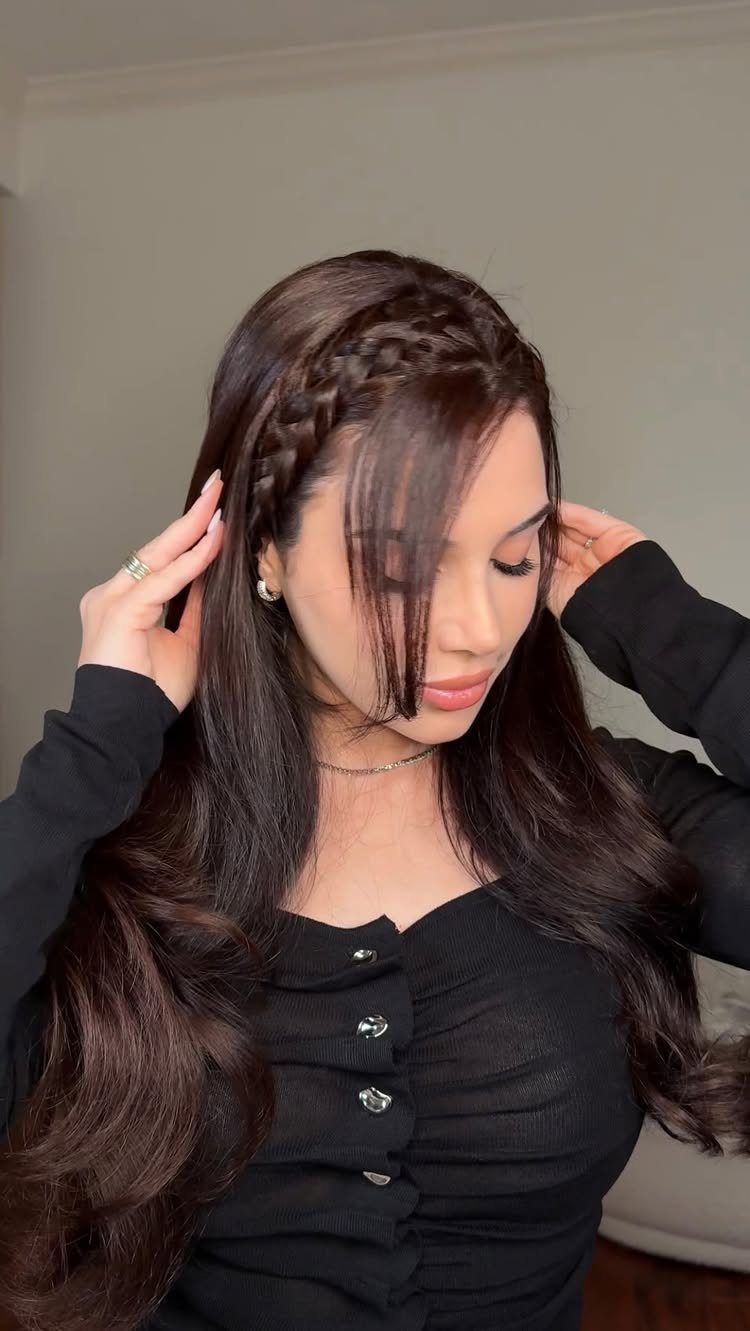 Woman with long dark brown hair styled in a braided crown and waves.