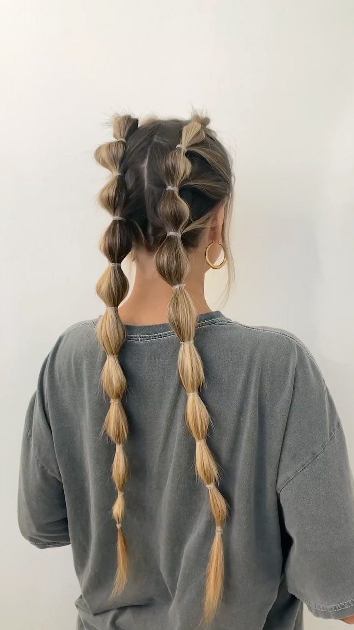 15 Ways to Pick a Hairstyle for Sweater Weather 7 Blonde hair styled in two long bubble braids with white elastic bands.