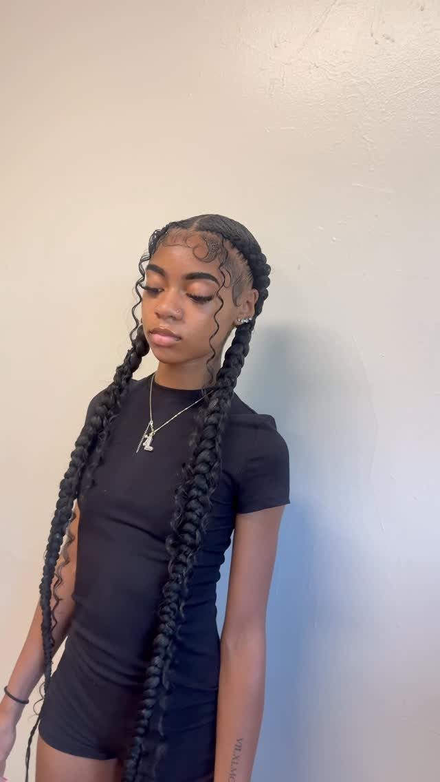 17 Hairstyles for Football Games: Braids, Buns & Ponytails 14 Young woman with long black braided pigtails and styled edges posing against white wall