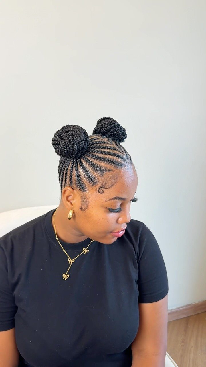 17 Hairstyles for Football Games: Braids, Buns & Ponytails 3 Woman with dark hair styled into two braided space buns and cornrows.