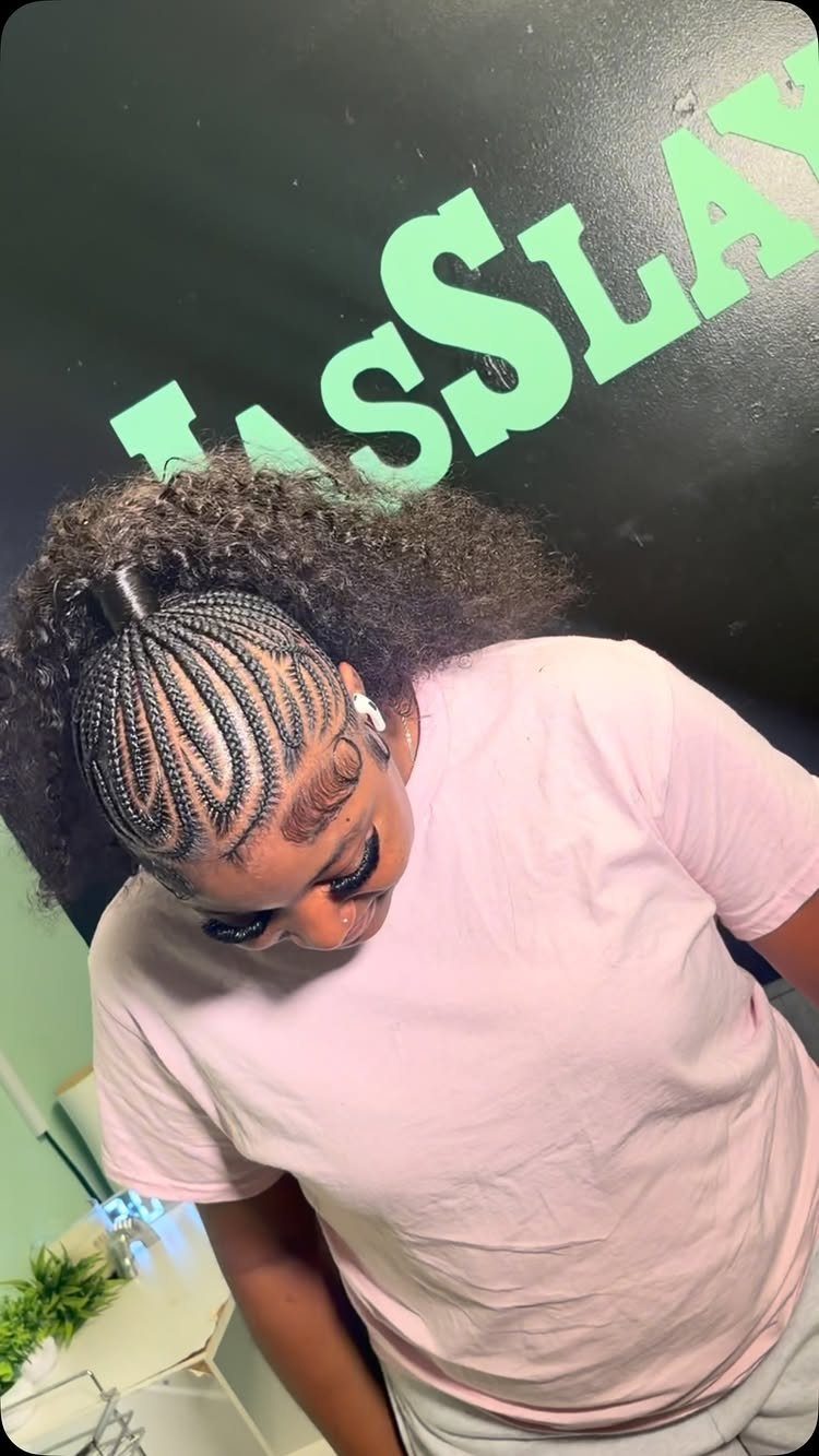 17 Hairstyles for Football Games: Braids, Buns & Ponytails 12 Woman with cornrow braids and a curly ponytail wearing a pink t-shirt.