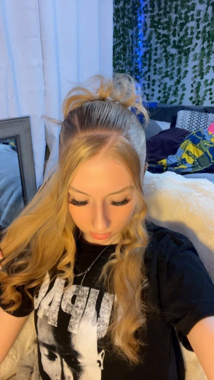17 Hairstyles for Football Games: Braids, Buns & Ponytails 7 Woman with blonde hair styled in a half-up high bun and loose curls.