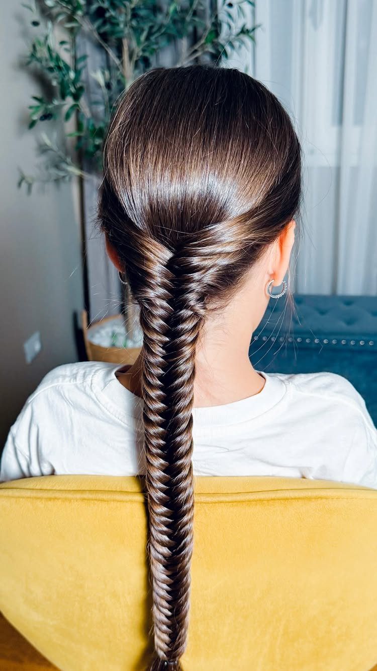 17 Hairstyles for Football Games: Braids, Buns & Ponytails 15 Long brown hair styled in a detailed fishtail braid on a person's back.