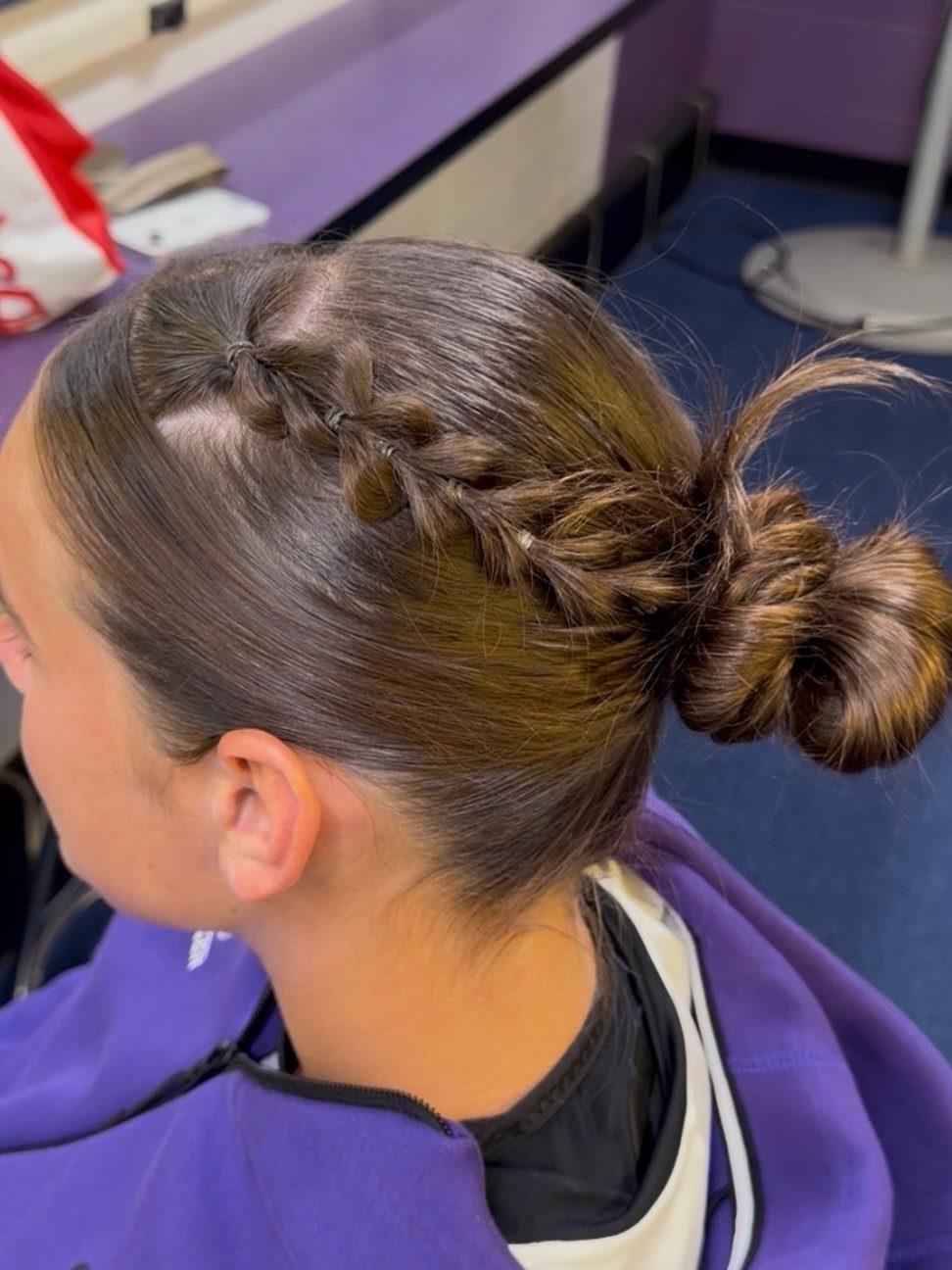 17 Hairstyles for Football Games: Braids, Buns & Ponytails 10 Brown hair styled in a side braid and a sleek low bun.