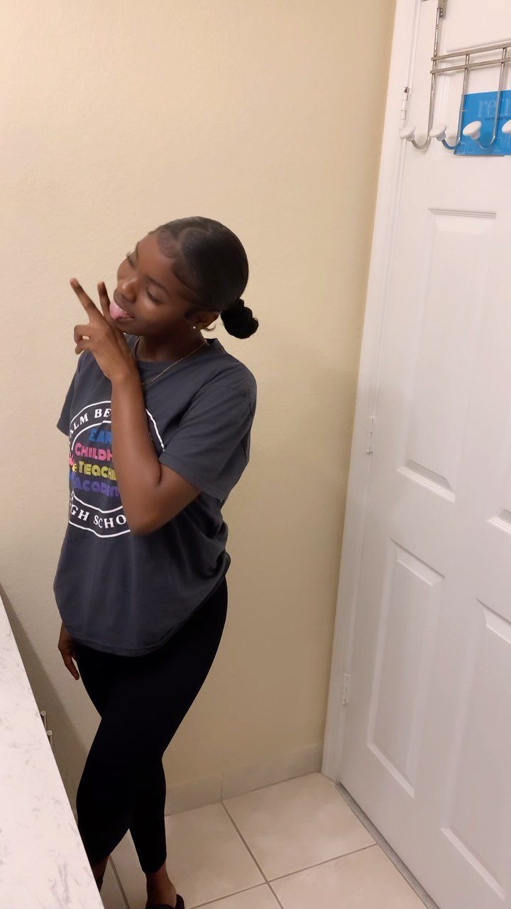 17 Hairstyles for Football Games: Braids, Buns & Ponytails 13 Young woman with a sleek low bun hairstyle posing in a room.
