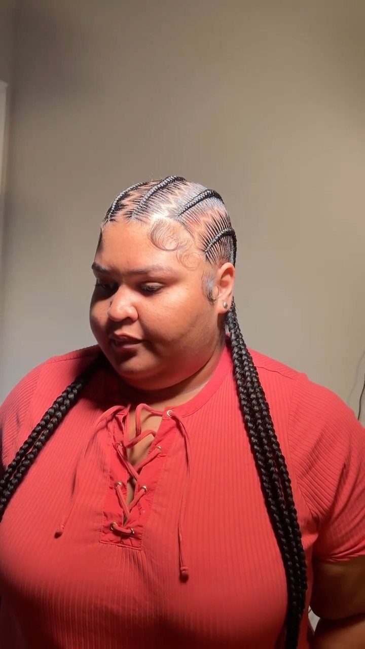17 Hairstyles for Football Games: Braids, Buns & Ponytails 9 Woman with zig-zag parted cornrows and long braids wearing a red top.