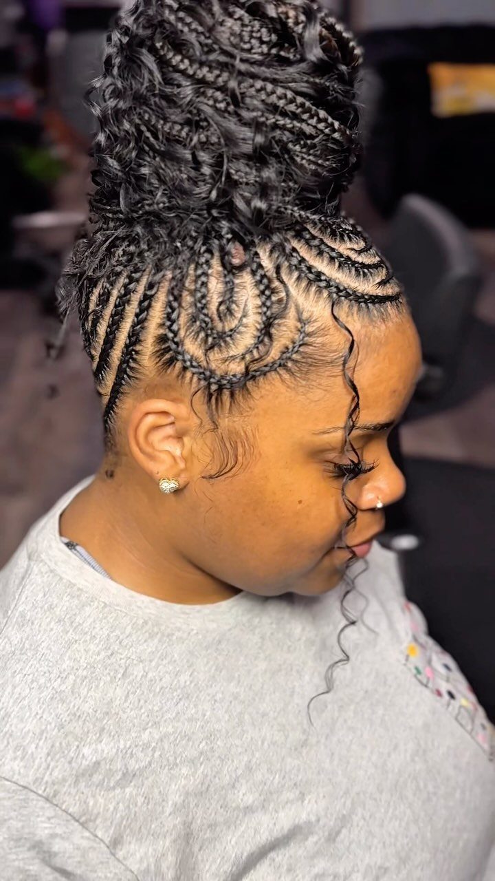 Woman with cornrow braids leading into a high curly bun hairstyle.