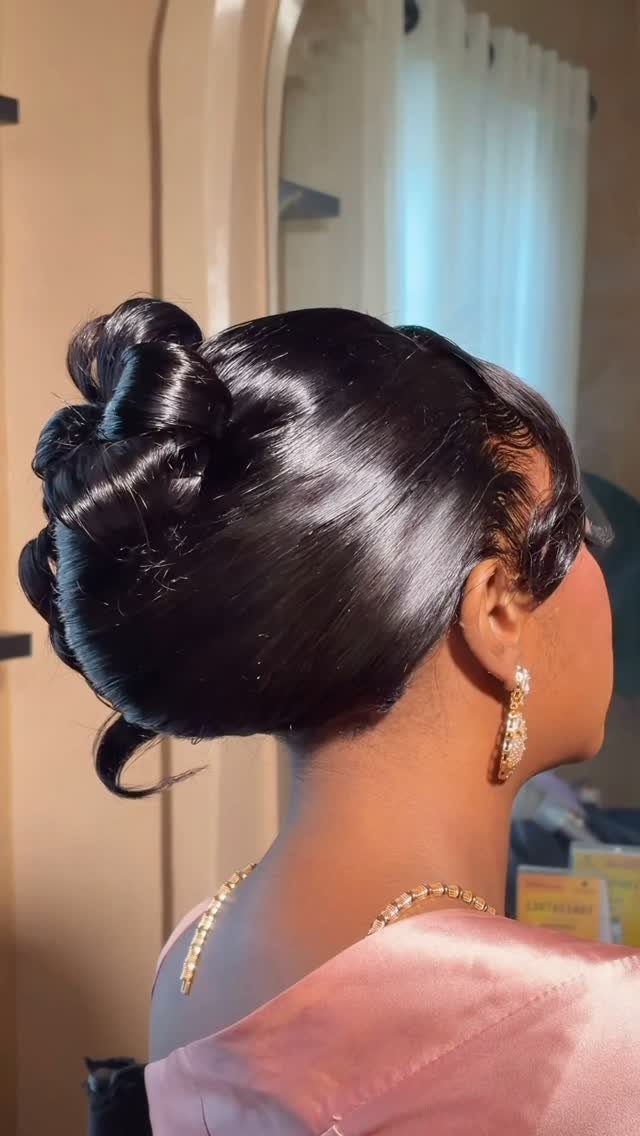 10 Hairstyles on Saree for Every Look and Occasion 6 Woman with glossy dark hair styled in a polished twisted bun and gold jewelry.