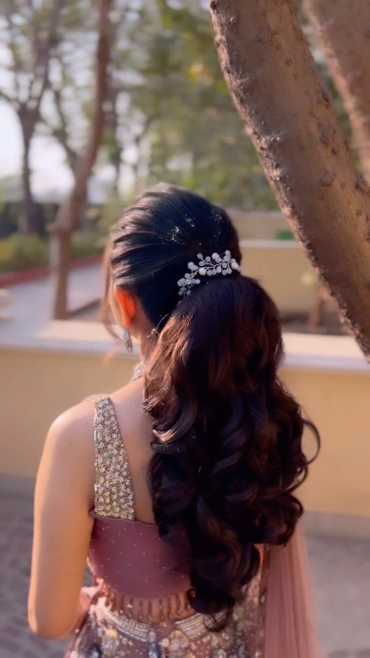 10 Hairstyles on Saree for Every Look and Occasion 10 Woman in mauve saree with curly ponytail and sparkling silver hair accessory