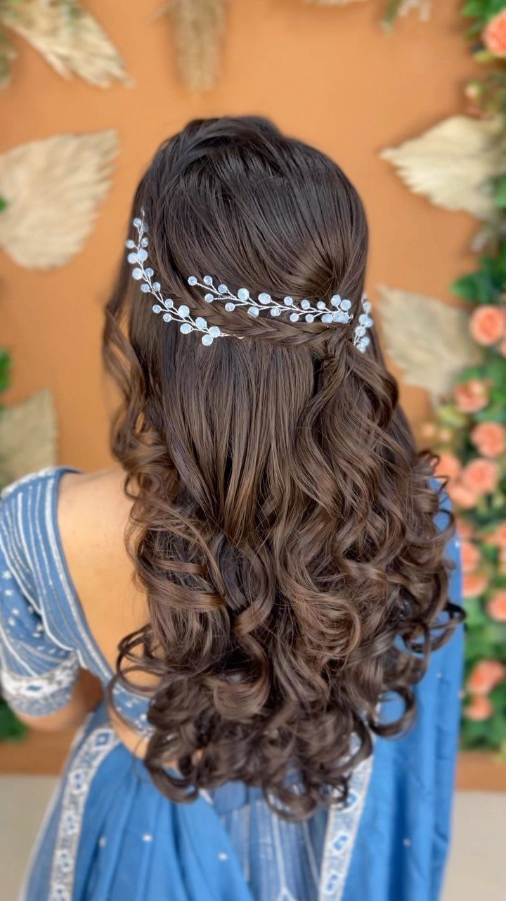 10 Hairstyles on Saree for Every Look and Occasion 1 Long brown curly hair in open waves with a silver floral hair accessory.
