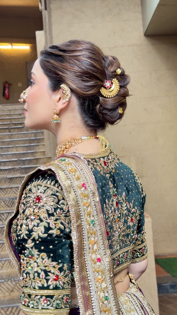 10 Hairstyles on Saree for Every Look and Occasion 5 Woman in green saree with a side-swept low bun and gold jewelry