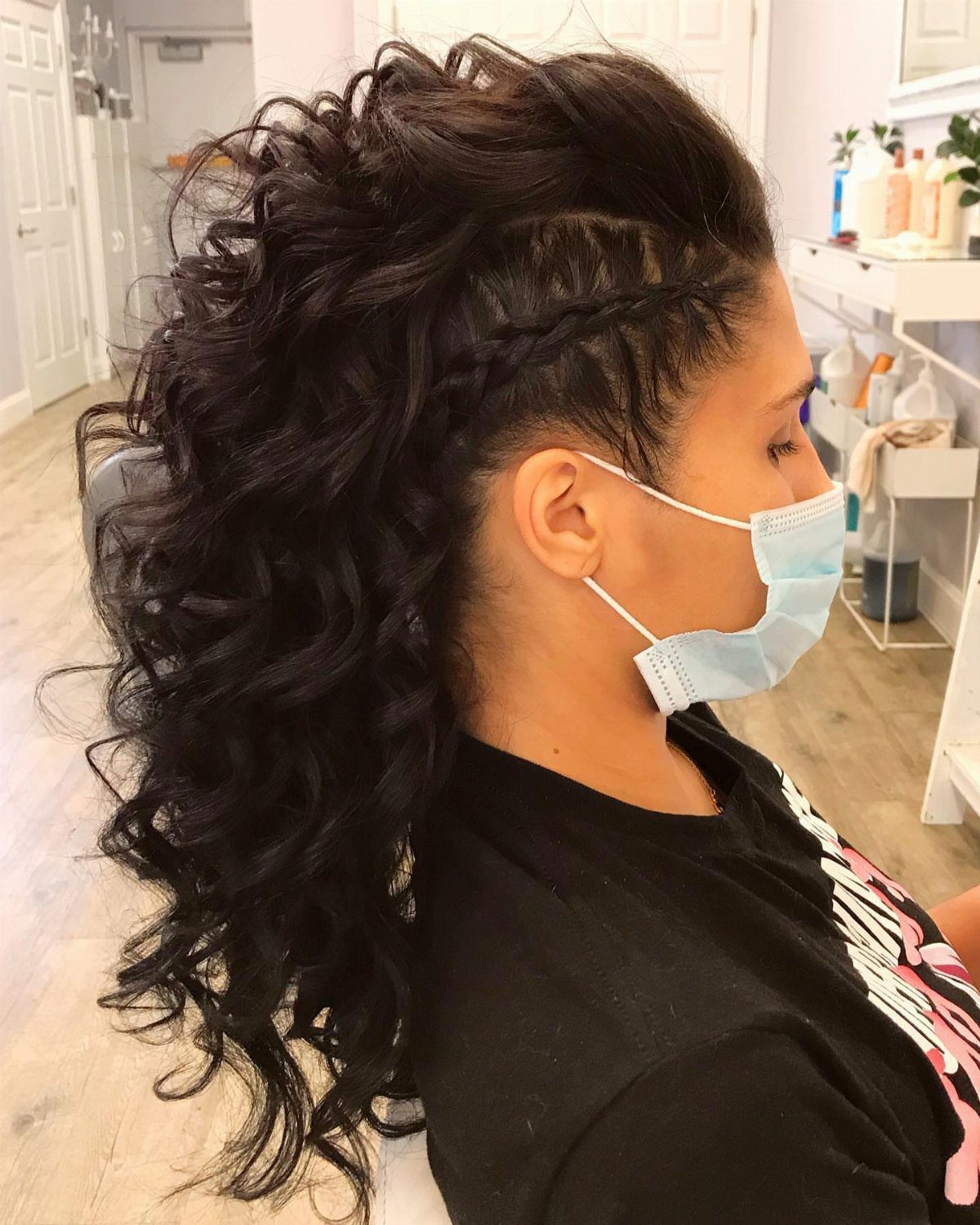 22 Hairstyles for Real Hair, from Bantu Knots to Bobs 10 Woman with a curly faux hawk hairstyle and braided sides wearing a mask.