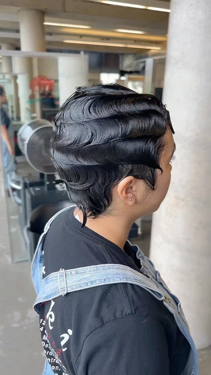 22 Hairstyles for Real Hair, from Bantu Knots to Bobs 13 Person with short black hair styled in glossy, sculpted vintage finger waves.