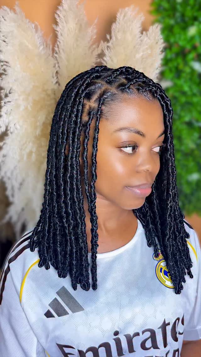 22 Hairstyles for Real Hair, from Bantu Knots to Bobs 12 Woman with shoulder-length black locs wearing a white soccer jersey.