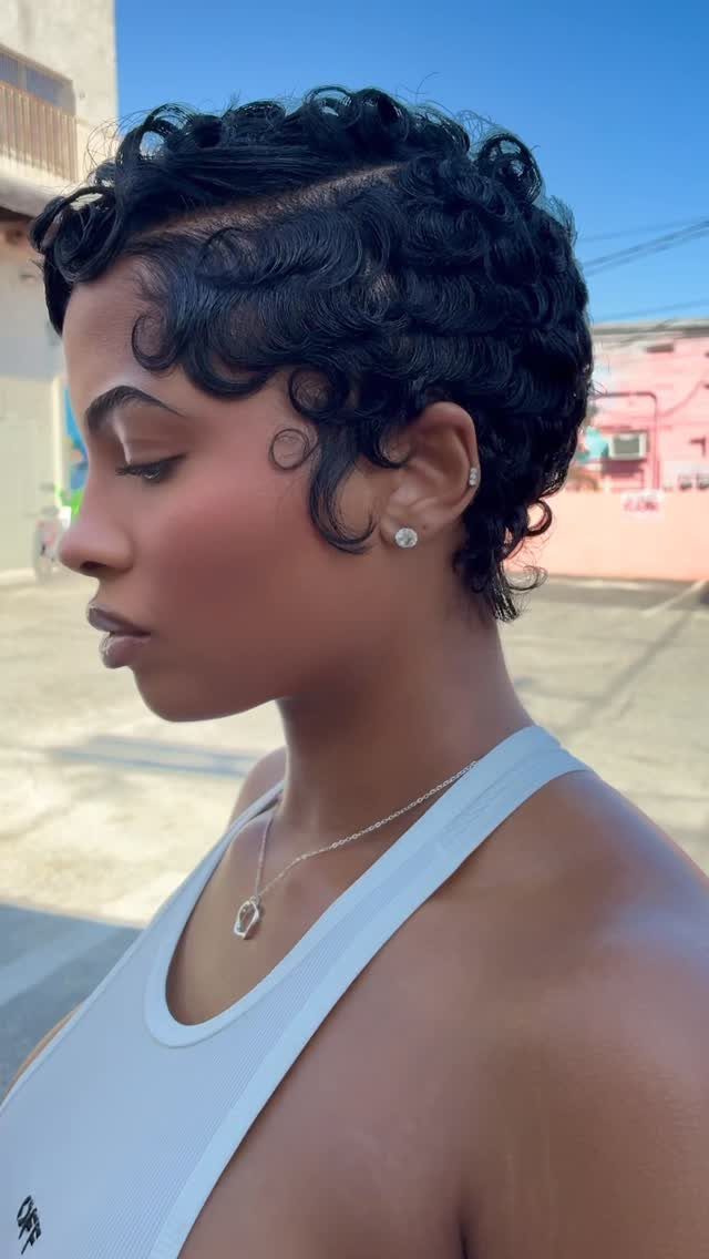 22 Hairstyles for Real Hair, from Bantu Knots to Bobs 17 Woman with short curly black hair styled in defined ringlets in profile view.